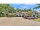 Stunning single-story home with stone accents, arched entry, mature landscaping, and paver driveway at 6774 Crescent Woods Cir, Lakeland, FL 33813