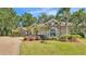 Charming home featuring stone accents, lush landscaping, and a circular driveway at 6774 Crescent Woods Cir, Lakeland, FL 33813