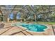 Screened-in pool area featuring a free-form pool with rock waterfall feature and outdoor seating at 6774 Crescent Woods Cir, Lakeland, FL 33813