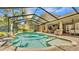 Gorgeous screened-in pool and spa with outdoor seating area perfect for entertaining guests at 6774 Crescent Woods Cir, Lakeland, FL 33813
