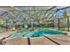 Beautiful screened-in pool with waterfall feature and lush landscaping creates a private backyard oasis at 6774 Crescent Woods Cir, Lakeland, FL 33813
