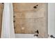 Close-up of the tiled shower with a shower head and handheld shower, with built in storage at 6774 Crescent Woods Cir, Lakeland, FL 33813