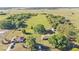Scenic view of the property showcasing the house, outbuildings, and surrounding green pastures with mature trees at 6981 Snell Rd, Bartow, FL 33830