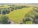 Sprawling land with lush grass and mature trees surrounding a building with outbuildings at 6981 Snell Rd, Bartow, FL 33830