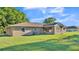 Backyard view of a single-story home surrounded by green grass and open space at 6981 Snell Rd, Bartow, FL 33830