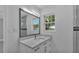 A modern bathroom vanity featuring a large mirror and a window providing natural light at 6981 Snell Rd, Bartow, FL 33830