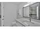 A bright bathroom featuring a vanity with white cabinets, sink, mirror, and a glass-enclosed shower at 6981 Snell Rd, Bartow, FL 33830