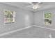 Bright bedroom with tile floors and two windows providing natural light and outdoor views at 6981 Snell Rd, Bartow, FL 33830