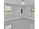 A bright bedroom with tiled floors, two sunny windows, and a modern ceiling fan and light fixture at 6981 Snell Rd, Bartow, FL 33830