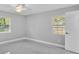 Serene bedroom with light gray walls, marble-look tile flooring, and two bright windows at 6981 Snell Rd, Bartow, FL 33830