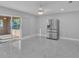 Open dining area with marble floors, sliding glass doors to the patio, and stainless-steel refrigerator at 6981 Snell Rd, Bartow, FL 33830