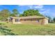 A single-story home with a well-maintained lawn and mature trees enhancing the property's curb appeal at 6981 Snell Rd, Bartow, FL 33830