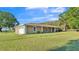 Single-story stucco home with attached garage, lush green lawn, and mature trees provides a peaceful and inviting curb appeal at 6981 Snell Rd, Bartow, FL 33830