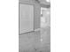 Bright hallway with white doors and marble-look floors, showcasing a glimpse into the kitchen at 6981 Snell Rd, Bartow, FL 33830