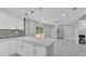Modern kitchen featuring white cabinets, a breakfast bar, stainless steel appliances, and access to the backyard at 6981 Snell Rd, Bartow, FL 33830