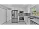Modern kitchen boasts stainless-steel appliances, white cabinets, and a window with a view to the outdoors at 6981 Snell Rd, Bartow, FL 33830