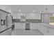 Bright kitchen features stainless steel appliances, white cabinetry, mosaic backsplash, a breakfast bar, and large windows at 6981 Snell Rd, Bartow, FL 33830