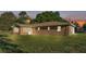 View of the rear of the home with an enclosed lanai, well-maintained lawn, and partial view of a fenced property at 6981 Snell Rd, Bartow, FL 33830