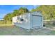 Exterior view of a metal shed with garage door in a backyard at 6981 Snell Rd, Bartow, FL 33830