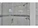 Close up of the shower with glass door and updated tile surround with decorative accent at 6981 Snell Rd, Bartow, FL 33830