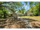 Spacious backyard with mature trees, path to house, and room for outdoor activities and entertaining at 7324 Thomas Jefferson E Cir, Bartow, FL 33830