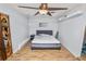 Bedroom with wood-look flooring, ceiling fan, decorative door and white walls at 7324 Thomas Jefferson E Cir, Bartow, FL 33830