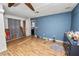Bedroom with wood-look flooring, blue accent wall, closet and doorway to the kitchen at 7324 Thomas Jefferson E Cir, Bartow, FL 33830