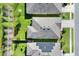 Overhead view of the home's roof, manicured lawn, and neighboring homes with dark solar panels at 7445 Ibis Dr, Lakeland, FL 33810
