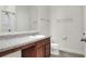 Bathroom featuring vanity with brown cabinets, a large mirror, and a shower/tub combo with chrome fixtures at 7445 Ibis Dr, Lakeland, FL 33810