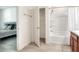 This well lit bathroom shows the tub with shower, cabinet, and bedroom access at 7445 Ibis Dr, Lakeland, FL 33810