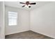 A bright, empty bedroom with a ceiling fan, window with blinds, and neutral-toned walls and flooring at 7445 Ibis Dr, Lakeland, FL 33810