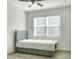 Cozy bedroom with a ceiling fan and a twin bed with a blue frame, storage drawers and a white comforter at 7445 Ibis Dr, Lakeland, FL 33810