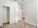 A bedroom with an open closet and neutral-toned walls and floors, featuring a window with blinds for natural light at 7445 Ibis Dr, Lakeland, FL 33810