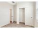 A bedroom with an open closet and neutral-toned walls and floors, featuring a window with blinds for natural light at 7445 Ibis Dr, Lakeland, FL 33810