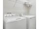 Functional laundry room equipped with modern washer and dryer units, complemented by overhead shelving for storage solutions at 7445 Ibis Dr, Lakeland, FL 33810