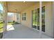 Covered patio features a concrete floor, neutral paint, square columns, and sliding glass doors to the home's interior at 7445 Ibis Dr, Lakeland, FL 33810
