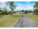 Long gravel driveway leading to a well-maintained home with mature trees at 900 Saddlewood Blvd, Lakeland, FL 33809