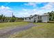 View of a home with gray siding and white trim, with a gravel driveway at 900 Saddlewood Blvd, Lakeland, FL 33809