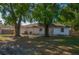 Backyard featuring grass, trees, a white house, a chain link fence and a patio at 1116 Durham Dr, Lakeland, FL 33809