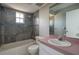 Bathroom with a shower over the tub, grey tile, and a pink topped sink at 1116 Durham Dr, Lakeland, FL 33809