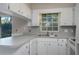 Well-lit kitchen featuring white cabinets and countertops providing a clean and efficient workspace with tile floors and wainscoting at 1116 Durham Dr, Lakeland, FL 33809