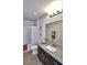 Modern bathroom featuring granite countertop, dark cabinetry, large mirror and shower/tub combo at 1537 Leamington Ln, Winter Haven, FL 33884