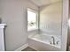 Bright bathroom featuring a soaking tub under a window, offering a relaxing spa-like experience at 1537 Leamington Ln, Winter Haven, FL 33884