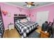 Cozy bedroom featuring a black and white plaid bed set, ceiling fan, and pink walls at 181 James Cir, Lake Alfred, FL 33850