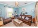 Comfortable living room with soft blue walls, natural light, and cozy leather sofa at 181 James Cir, Lake Alfred, FL 33850