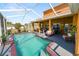 Screened-in pool with a waterfall feature, lounge seating and an orange house exterior at 181 James Cir, Lake Alfred, FL 33850