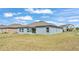 Home exterior with sliding glass doors and several windows that overlook the green backyard at 2983 Flying Blackbird Rd, Bartow, FL 33830