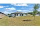 Exterior of home with a grassy yard, small trees, and visible windows under a blue sky at 2983 Flying Blackbird Rd, Bartow, FL 33830