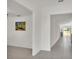 Bright hallway featuring neutral paint, tile floors, and an open floor plan with a decorative print at 2983 Flying Blackbird Rd, Bartow, FL 33830