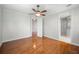 Neutral bedroom with hardwood floors, ceiling fan, and a glimpse into the ensuite bathroom at 2997 Mission Lakes Dr, Lakeland, FL 33803